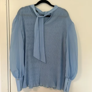 Blå blus - Blå superfin blus från NA-KD. Vet inte vad storleken är men skulle nog säga M beroende på hur tight/löst man vill att den sitter.