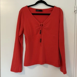 Tröja - Orange/röd tröja med utsvängda armar. 