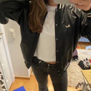 Snygg bomberjacka - Unik bomberjacka köpt här på Plick för några år sen! Jag är själv 178 så den blir snyggt oversized på någon kortare. Lite slitage på trycket som fannns där när jag köpte den.