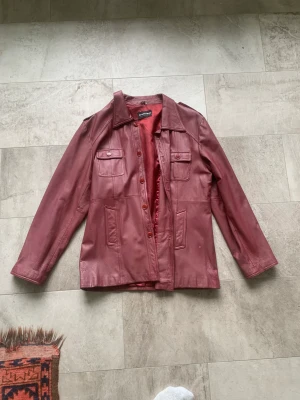 Skinnjacka vintage - En vintage skinnjacka i toppskick. Rödlila, dammodell i xxl, funkar både på herr(jag) och till dam. Jag är 190cm. 