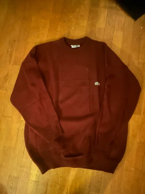 Vintage Lacoste stickad  - En snygg vintage Lacoste stickad tröja i em jätte fin röd färg! Står storlek XXL men sitter mer som en najs L i mina ögon!