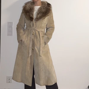 Läder kappa  - Extremt fin och varm kappa i 100% läder och äkta pälskrage, den är trasig i den ena fickan då tyget har lossnat men går fortfarande att använda fickan och det är inget som stör! 