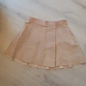 Mocka/skinn kjol från HM Veckad utsvängd  Dragkedja i sidan Supersnygg! Inget att anmärka på.