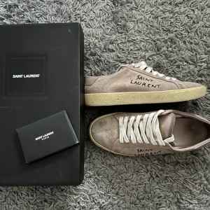 YSL skor - Säljer mina svinsnygga sneakers från YSL då de inte passar mig och därav inte kommer till användning. Köpta för 495€ vilket motsvarar ca 5900kr. Säljs med låda och äkthetsbevis. Skriv för frågor eller fler bilder. Pris kan diskuteras vid snabb affär.