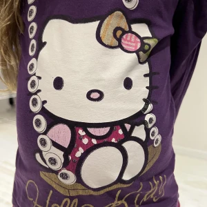 Långärmad tunn HELLO KITY tröja (110/116) - En långärmad tunn HELLO KITTY tröja i fint skick och storleken 110/116.  Finns en namnmärkning på lappen i nacken med initialerna ”AW”.