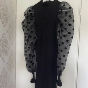 Miniklänning med mesh - Svart miniklänning med mesh-ärmar, stickad material på klänningen, stretchig, högre hals, använd 1 gång