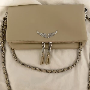 Zadig väska - Fake köpt i Spanien, men ser äkta ut! Inget använd då den är silver jag använder guld! Den är i en jättefin baige färg😍😍Köpt för 300kr Om många är intresserade så blire budgivning! 66kr för spårbar frakt