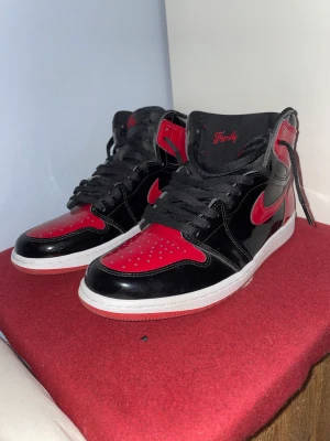 Jordan 1 high patent -  Man får med Box, kvitto och nyckelringen jag har köpt dem för 3500kr på afroUrbanshop på emporia Storlek 43 jordan 1 high patent  Ny skick använda runt 10 gånger 