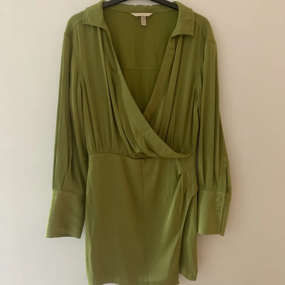 Säljer denna super fina klänningen från H&M som jag köpte för ca 1 år sedan. Aldrig använt den. Jätte fin oliv grön färg!. Klänningar.