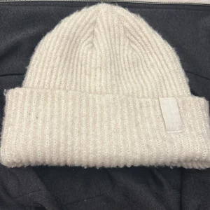 mössa - en beige mössa från hm i storlek one size som inte kmr till användning