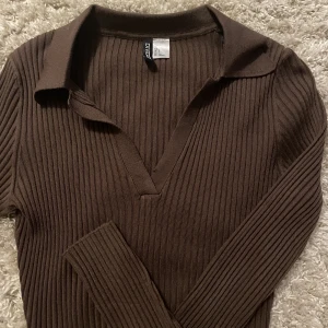 Topp - En brun långärmad topp som är croppad. Oanvänd 