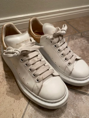 Alexander Mqueen skor guld/vit - Tjena!! Säljer dessa unika mqueen skor pga att ja inte längre använder dom. Köpta för 3000kr på Kaspersheat.  Använt mycket men tagit väl hand om dessa😊 dom har lite repor på hälen men annars inga skador!😇 storlek 42. Buda gärna!
