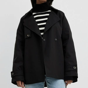 Svart kort trenchcoat  - Säljer då den inte kommer till användning. Jackan är sparsamt använd & i nyskick. Den är helt slutsåld & säljs inte längre. Nypris: 1300kr. Passformen är lite oversized! Priset kan gå att diskutera vid snabb affär. Skriv om du har frågor! 🫶🏼