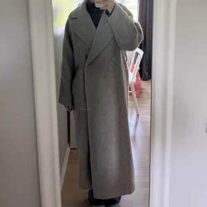 Lång Kappa - Lång kappa i ullblandning från Weekday. Går till ankeln på mig som är 176 cm och sitter lagom oversize. Har använt några få gånger, men känner inte att färgen passar mig. Kappan är lite ”ullig”, men det går att borsta ut med en ullborste. Köpt för 1100kr 