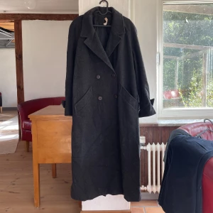Lång oversized ullkappa strl 36-42 - Vintage ullkappa inköpt second hand i Paris. I fint begagnat skick bortsett från ett hål i ena fickan. Mysig och oversized, men kommer tyvärr inte till användning längre. Okänd storlek men passar 36-42 beroende på hur man vill att den ska sitta!
