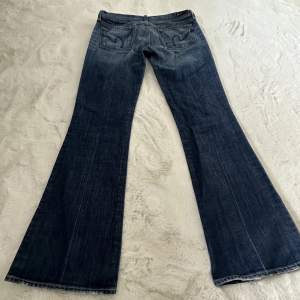 Säljer ett par Lågmidjade jeans från märket Citizens of Hummanity💙 Jeansen är breda nertill, börjar bli breda vid knät. Väldigt fin wash, samt detaljering på fickorna!  De är i extremt bra skick!   Mått: midja platt 40cm    innerbenslängd 83cm