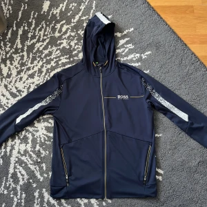 Blå Hugo boss zip hoodie - Blå hoodie med zip och luva, använd några gånger, köpt för 1300kr