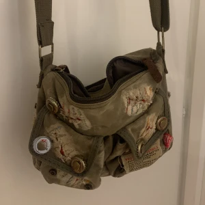 grön axelremsväska  - skit cool axelremsväska! praktisk o enkel o otroligt detaljerad, kommer aldrig till användning så säljer! 