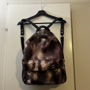 Ryggsäck  - Ryggsäck sliten vid axelbanden. Resten i fint skick om någon har tid och lust att reparera.  Många fickor på insida och utsida. Märket är ”Ulrika”.