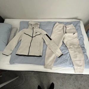 Nike tech dress - Säljer min Nike tech dress i färgen vit som knappt är använd. Tröjan är i storlek S och byxorna i storlek M. Nypris 2200