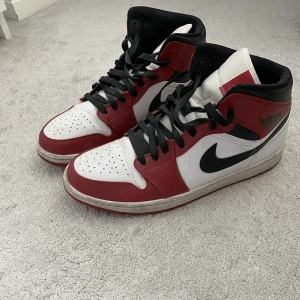 Nike Jordan 1 Mid Chicago - Säljer nu mina Jordan 1 Chicago då jag inte använder de längre. Använt endast några gånger. Bra skick, ingår crease skydd. Storlek 45,5