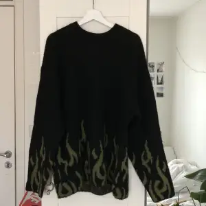 En svart stickad tröja från weekday med gröna flammor. Använt tröjan ett fåtal gånger den är i väldigt bra skick, Storlek M Köpt för 600kr säljer för 400kr inklusive frakt 
