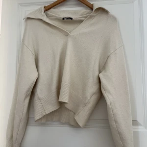 Stickad tröja med krage - Krämvit stickad tröja med krage. Modellen är lite kortare. Den är knappt använd
