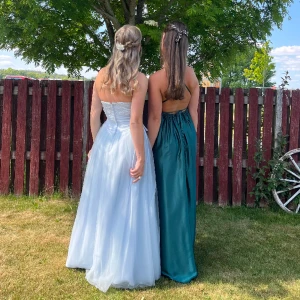 Balklänning - Säljer min vackra isblåa balklänning !!🥲💋 Otroligt fin & så bra material. Hård korsett upptill med dragkedja bak och knyten med fina snören på sidorna. Sitter verkligen uppe! Pärlor på bröstet oxå 😍 Nypris : 3000 Jag är 170, har klackar på bilderna :)