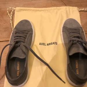 Arigato Skor - Ett par gråa arigatos som är köpta för 2500kr. Det är i ett 7/10 skick eftersom de har blivit lite mörkare och arigato märket har blivit lite suddigare. Box och påse ingår. Ser mycket bättre ut i verkligheten.