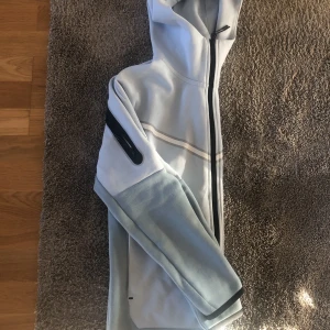 Nike tech  - Säljer denna Nike tech tröja då den aldrog kommer till användning och är i nyskick. Färgen ärlige himmelsblå och extremt snygg, köpt på jd sports. Tveka inte på att höra av dig då priset går att diskutera!