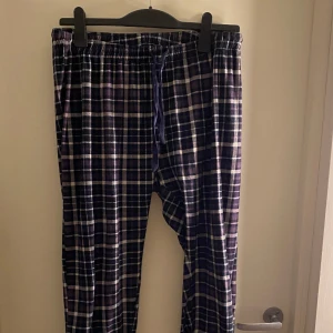Pyjamasbyxor - Lila/marinblåa pyjamasbyxor i storlek M, lite stora i midjan men man kan ju knyta dom. Muddar nere vid fötterna. Osäker på märket.