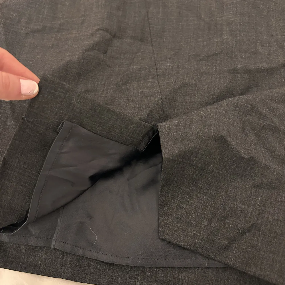 Säljer denna fina korta kjol från STOCKH LM🩶 •Aldrig använd. •Mörk grå  •Slits där nere och dragkedja på sidan!. Kjolar.