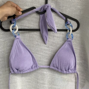 Snygg bikini - Helt ny bikini i ribbat tyg med fina detaljer. Köpte två olika storlekar när jag var i usa. Står L men det känns mer som en M. Långa band så det går att justera storleken