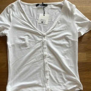 V-ringad vit t-shirt - Aldrig använd. Lite genomskinlig men inte mycket, bra och fin kvalite. Polyster tyg☺️