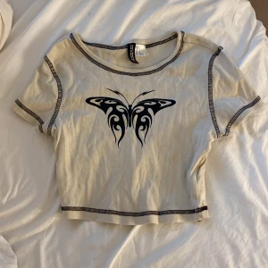 T-shirt med tryck - Söt T-shirt med fjärils tryck. Nästan aldrig använd.  Orginalpris: 150 kr Storlek: XS  