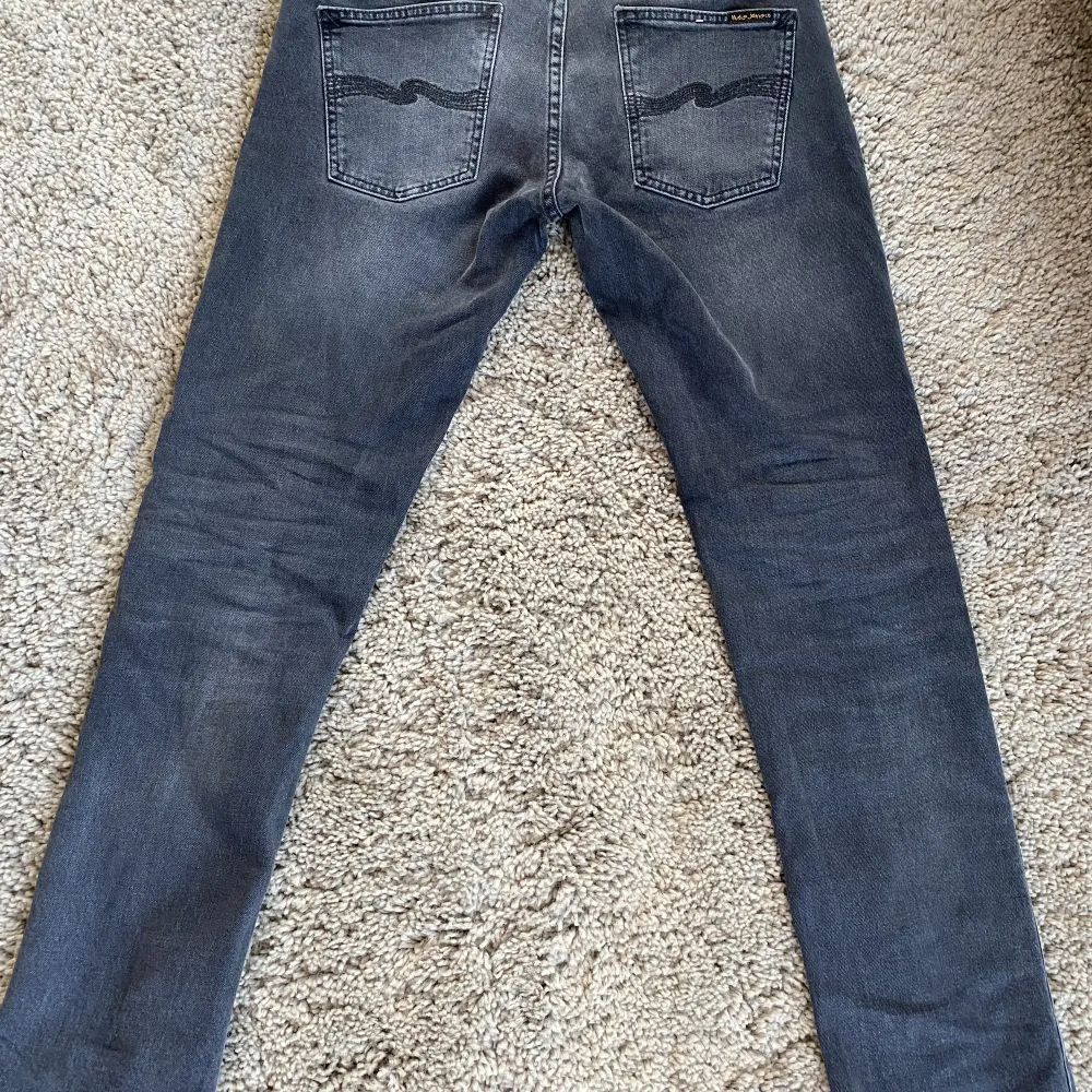 Säljer dessa väldigt trendiga Nudie jeans grim tim. De är i en väldigt snygg svart färg och grå. De är i bra skick och de har ingen skada på dem alls. Är lättåtkomlig och svarar snabbt. Nypris 1600kr, mitt pris 400. . Jeans & Byxor.