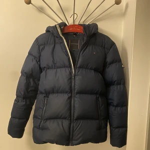 Tommy Hilfiger vinterjacka - Storlek 176 passar även vuxenstorlek S utan problem. Sparsamt använd och i ett 8/10 skick. Nypris 1400 kronor. Priset kan diskuteras!