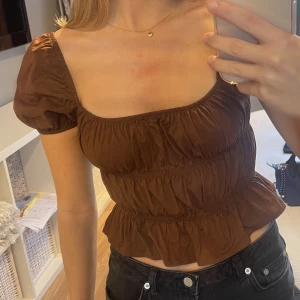 Brun topp - Superfin brun topp från Bershka, med lite puffiga armar och resårband runt midjan.  Köparen står för frakt <3