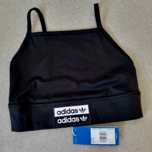 Adidas crop top - Skitsnygg crop top från adidas med prislappar kvar!  Öppen rygg.  Storlek 34