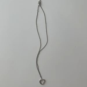 Silvrigt halsband  - Silvrigt halsband med ett hjärta på, vet inte vart det är köpt ifrån 