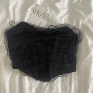 Korsett topp - Säljer denna snygga svarta korsett topp med snygga detaljer från Zara! Aldrig använd, därav sitter prislappen kvar.🙌🏼😍 Säljer för 269kr