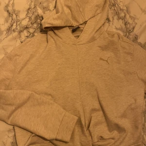 Grå Puma hoodie  - En ljusgrå hoodie från Puma som knappt är använd. Den är en kortare hoodie. Väldigt fräsch 