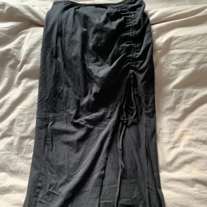 Svart kjol  - Långkjok med slits, kan ändra vart slits ska sluta genom att knyta 