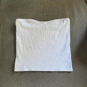 Tub topp - Vit tub-topp från Gina tricot i nyskick. Endast använd en gång. Inte genomskinlig och den håller sig uppe då den har en  silikonrand högst upp på toppen