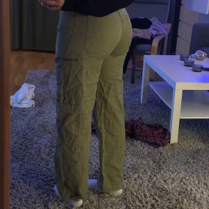 Cargobyxor - Militärgröna cargobyxor med raka ben, byxorna är föör små för mig så de blir automatiskt kortare på mig. Annars är de bra längd