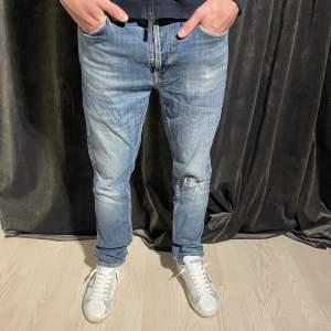 Ett par riktigt stiliga jeans från Nudie i modellen Lean Dean. Dem är i storlek 32 och har ett hål på knät som syns på bild nummer 1. Modellen på bilden är 180cm och väger 67kg!🙌🏼