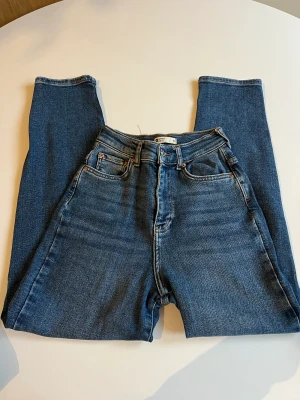 Blå jeans  - Knappt använda ”ballong” jeans från Gina Tricot i storlek 32 petite.De är även high waist. Men mjukt material av jeans. 