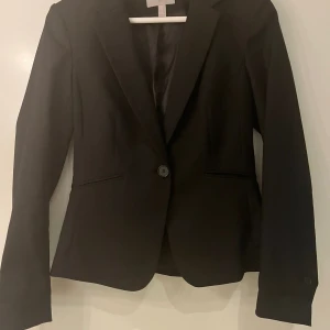 Kavaj - Svart kavaj från H&M. Knappt använd, i nyskick. 