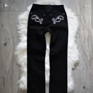 Lågmidjade utsvängda jeans  - Jättesnygga svarta utsvängda jeans med detaljer på bakfickorna. Köpta nyskick secondhand och aldrig använda av mig pågrund av att de var för små😔💖