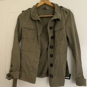 Kort trenchcoat/utility jacka i Khaki - Kort trenchcoat/utility jacka från H&M  Fin kvalitet 
